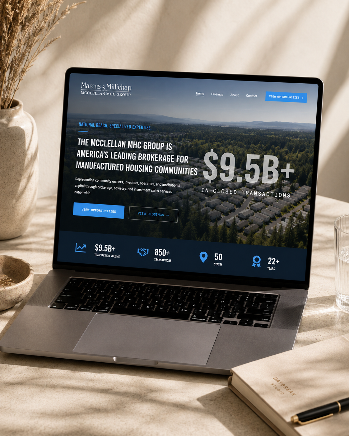 Laptop on desk showing Marcus & Millichap website about $9.5B closed transactions in manufactured housing. A Website designed by Daybreak Creative Studio