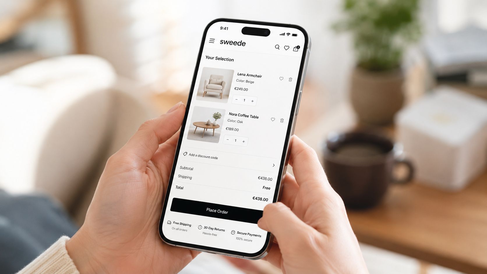 A person holding a smartphone displaying an online furniture store cart with two selected items.