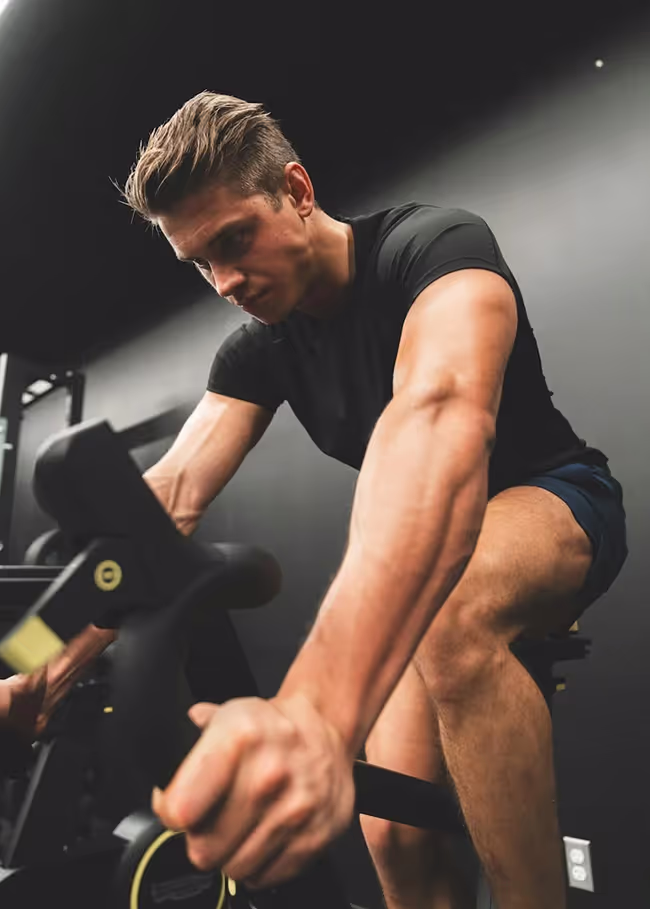 A man in a black shirt is doing exercises on a machine.