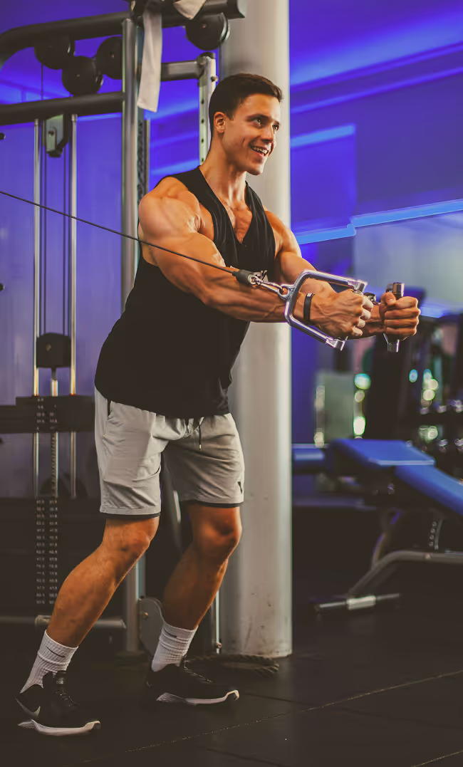 A man in a gym holding a rope.