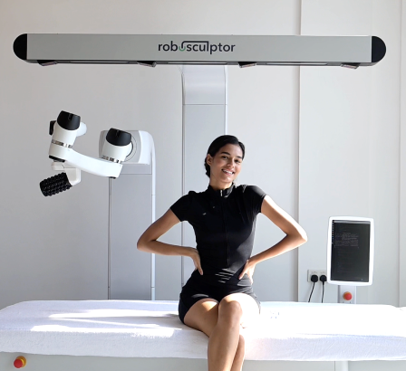 Happy woman sitting on roboSculptor table after massage procedure