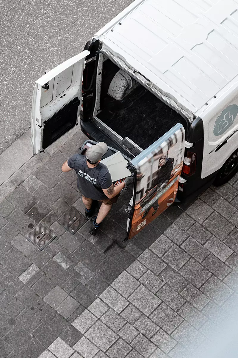 EntrümpelungRLP Mitarbeiter verstaut Gegenstand in Firmenfahrzeug