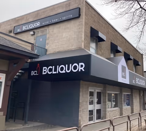 Exterior of a two-story building with BCLiquor signage advertising wine, beer, and spirits.