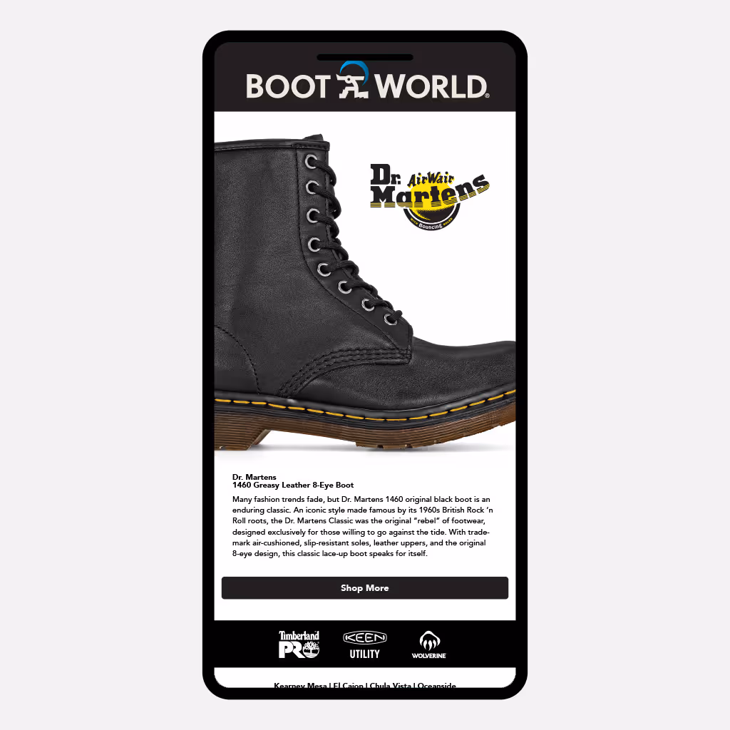 Mobile screen mockup displaying a Boot World email featuring a black Dr. Martens 1460 Greasy Leather 8-eye boot, with Boot World and Dr. Martens branding, product description text, a “Shop More” button, and additional footwear brand logos at the bottom.