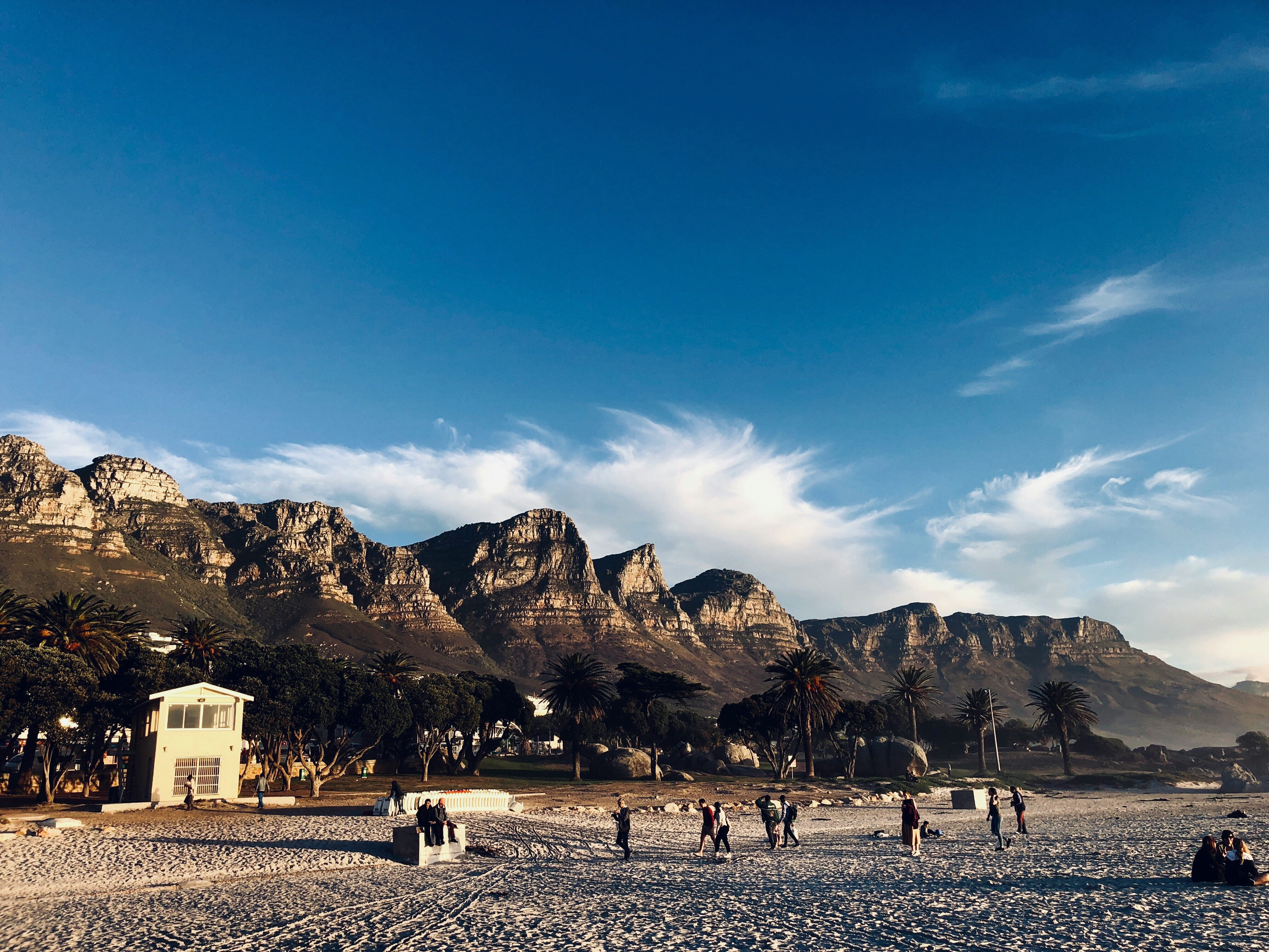 Leute an einem Strand mit Bergen im Hintergrund