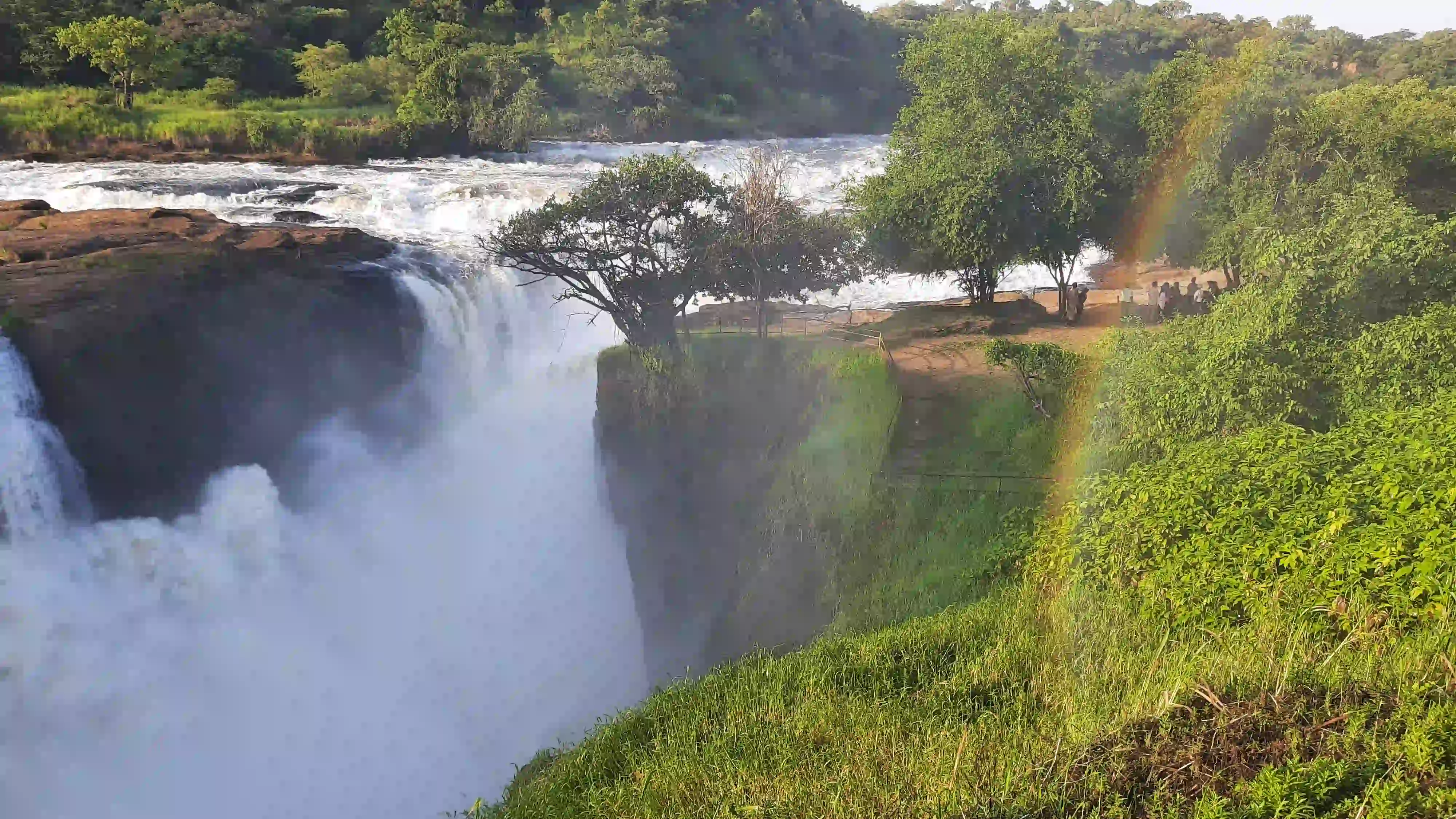 Blick auf einen Wasserfall, daneben erstreckt sich ein Regenbogen