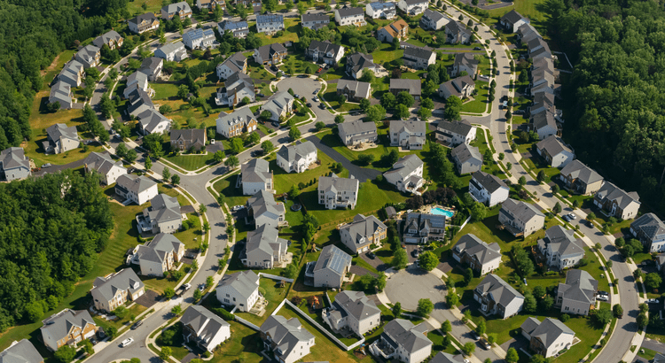 Aerial view of a suburban neighborhood with single-family homes and tree-lined streets.