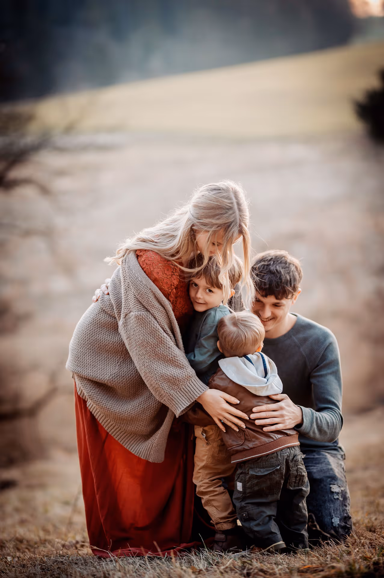Vater und Mutter umarmen ihre Kinder - Familienfotografie in der Nähe von München