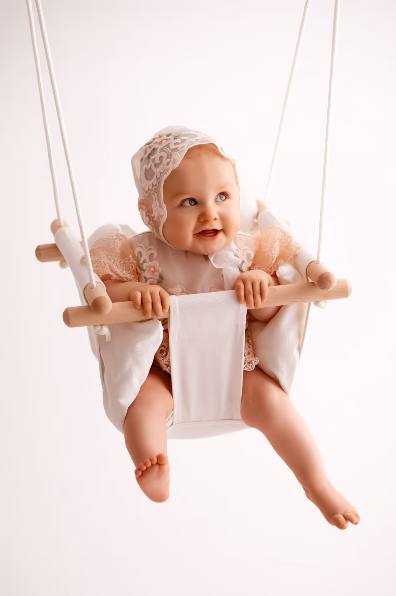 Baby in einer Kinderschaukel im Fotostudio in Aichach - Fotografie von Natalia Günsche