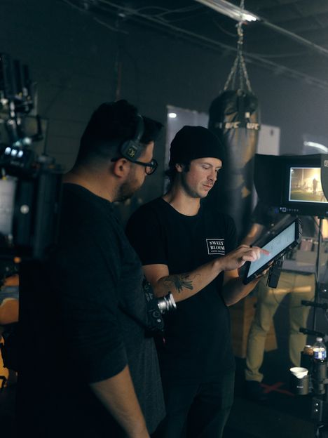 Two filmmakers review a shot together on a tablet beside the camera