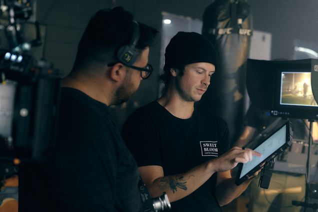 Two filmmakers review a shot on a tablet beside the camera
