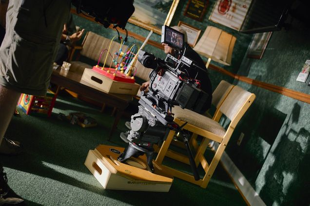 A cinema camera built up on a cart inside a cluttered workshop