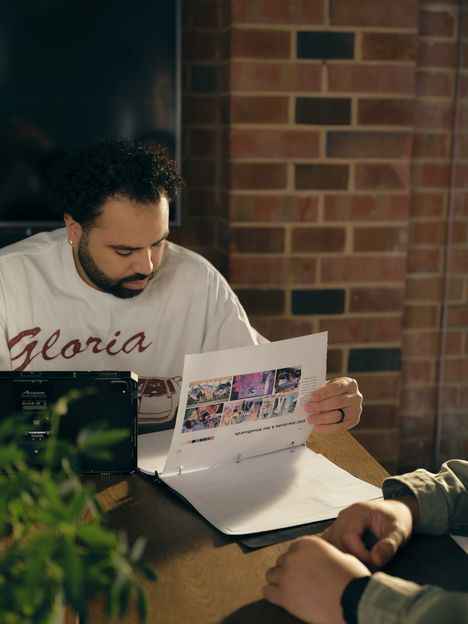A filmmaker holding up a printed contact sheet of reference frames
