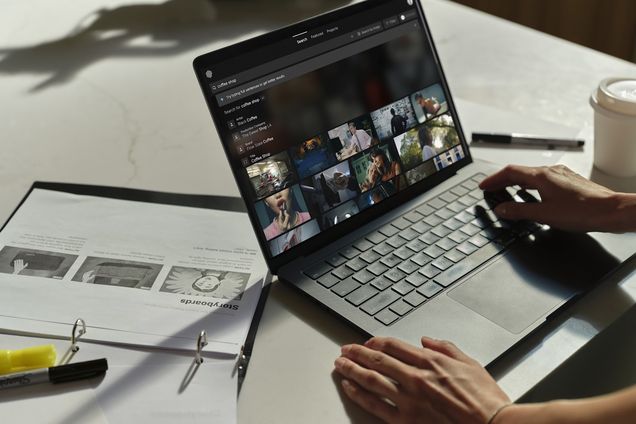 Hands at a laptop showing a grid of Frames on a studio table