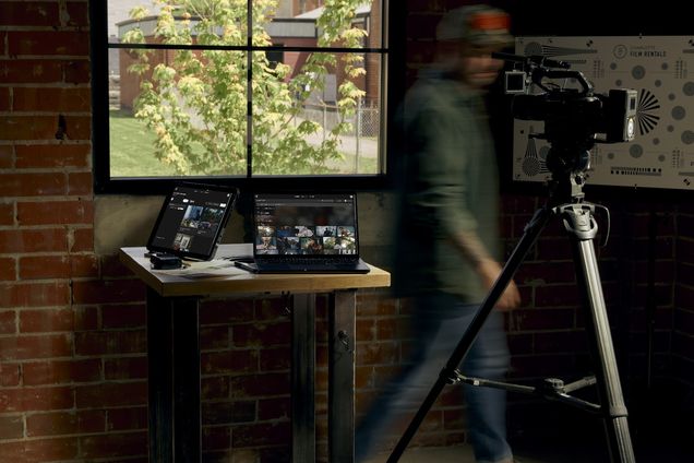 A standing desk with Frame Set on screen and a figure passing behind it