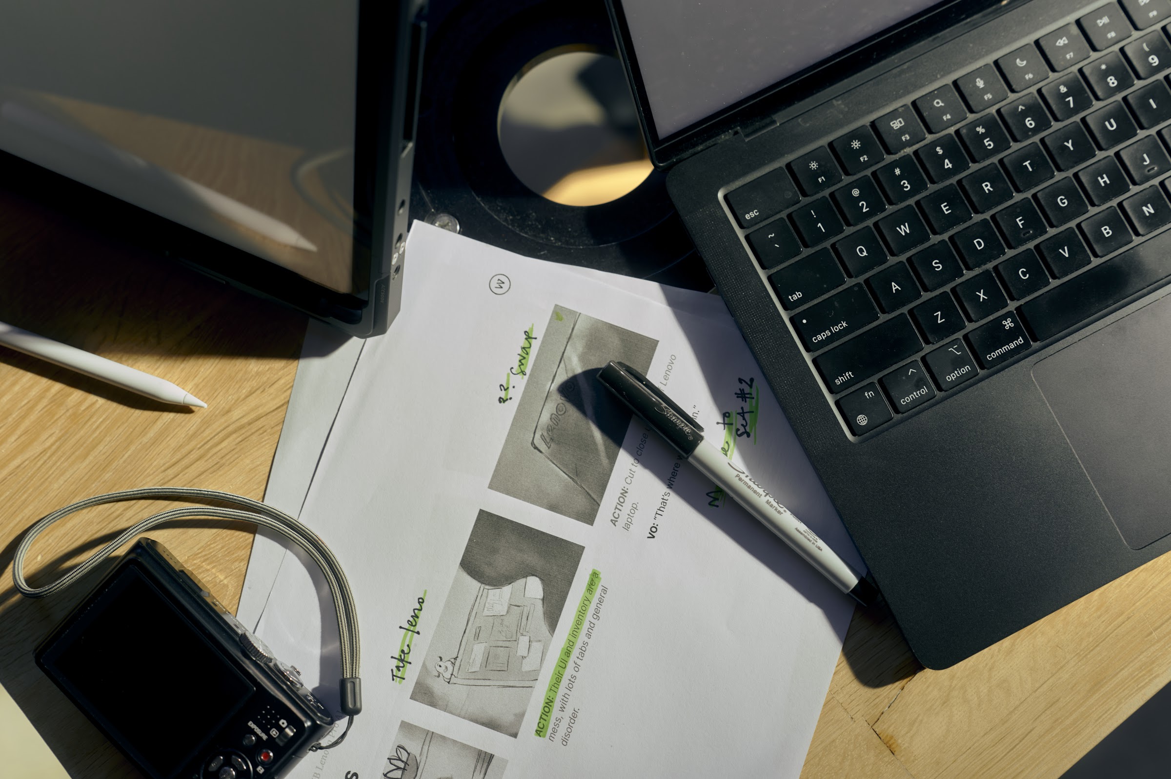 A pre-production desk with a laptop, storyboard pages, and a camera.