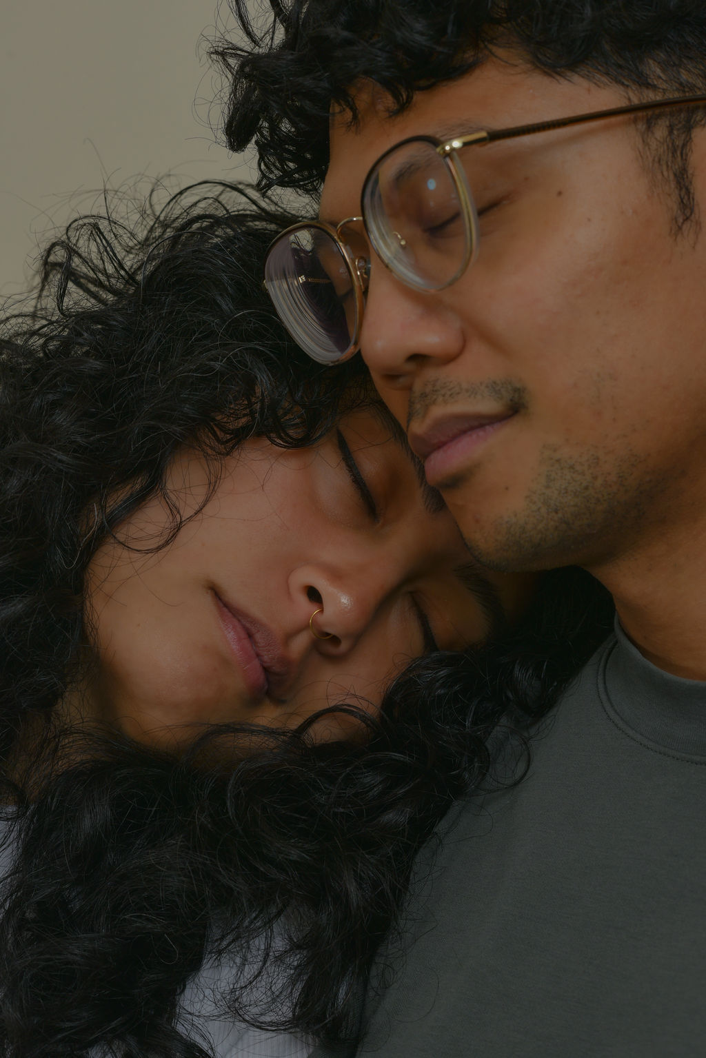 Leanne, with her eyes closed, pressing her head against Jason's shoulder while Jason, also eyes closed, is resting his head over Leanne's head.