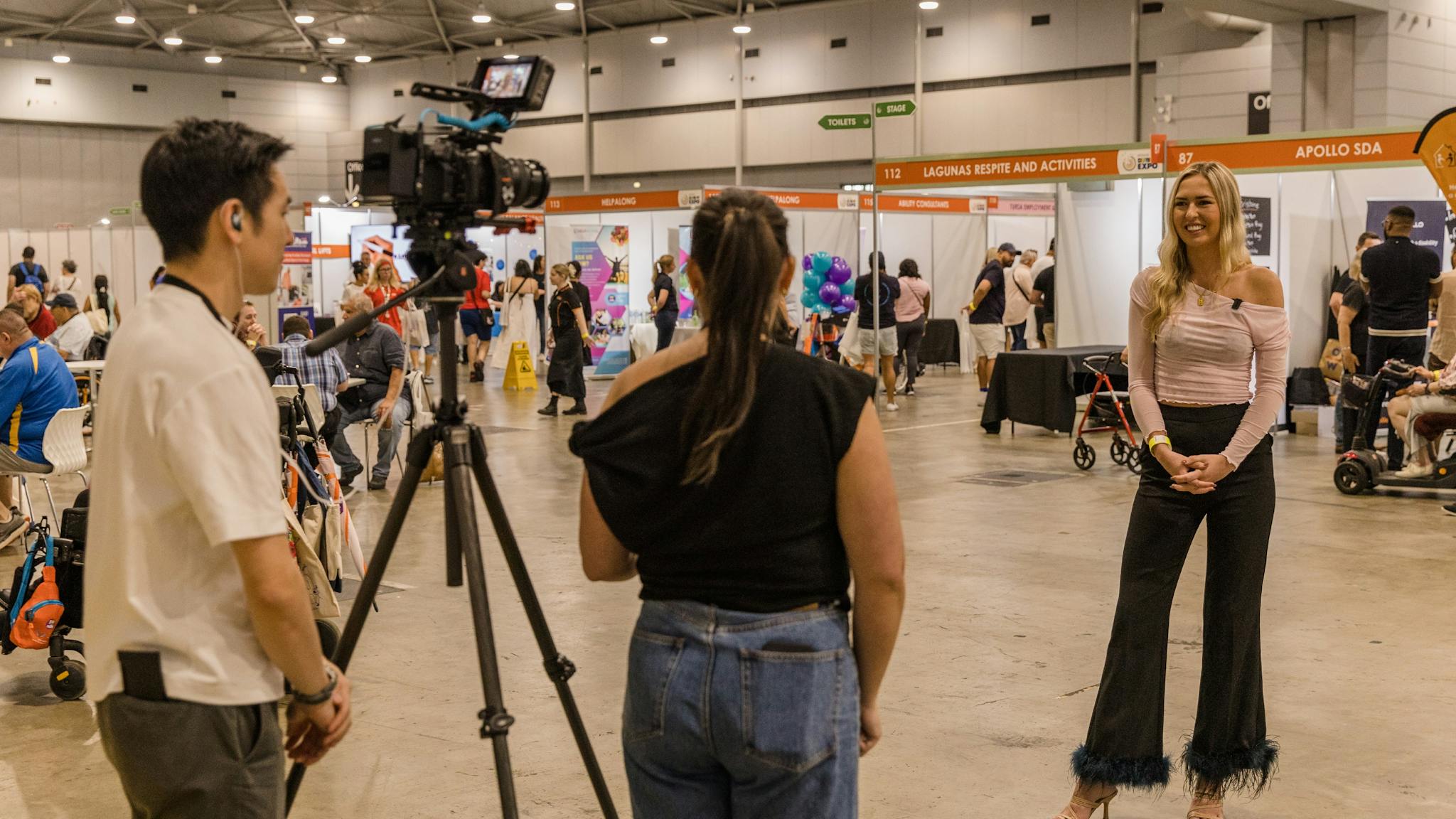 Two staff members interviewing Ambassador Anja Christoffersen at Brisbane 2024
