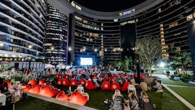 People at an outdoor cinema behind Queen's Wharf