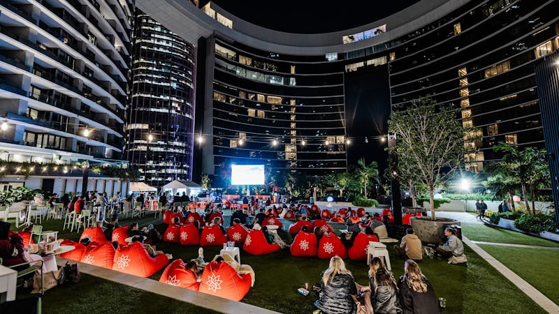 People at an outdoor cinema behind Queen's Wharf