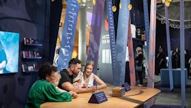 Guests sitting at a table inside exhibition space