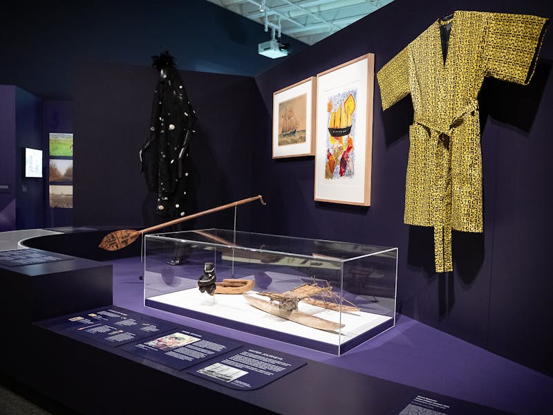 An exhibition space with objects on display including a yellow smoking jacket