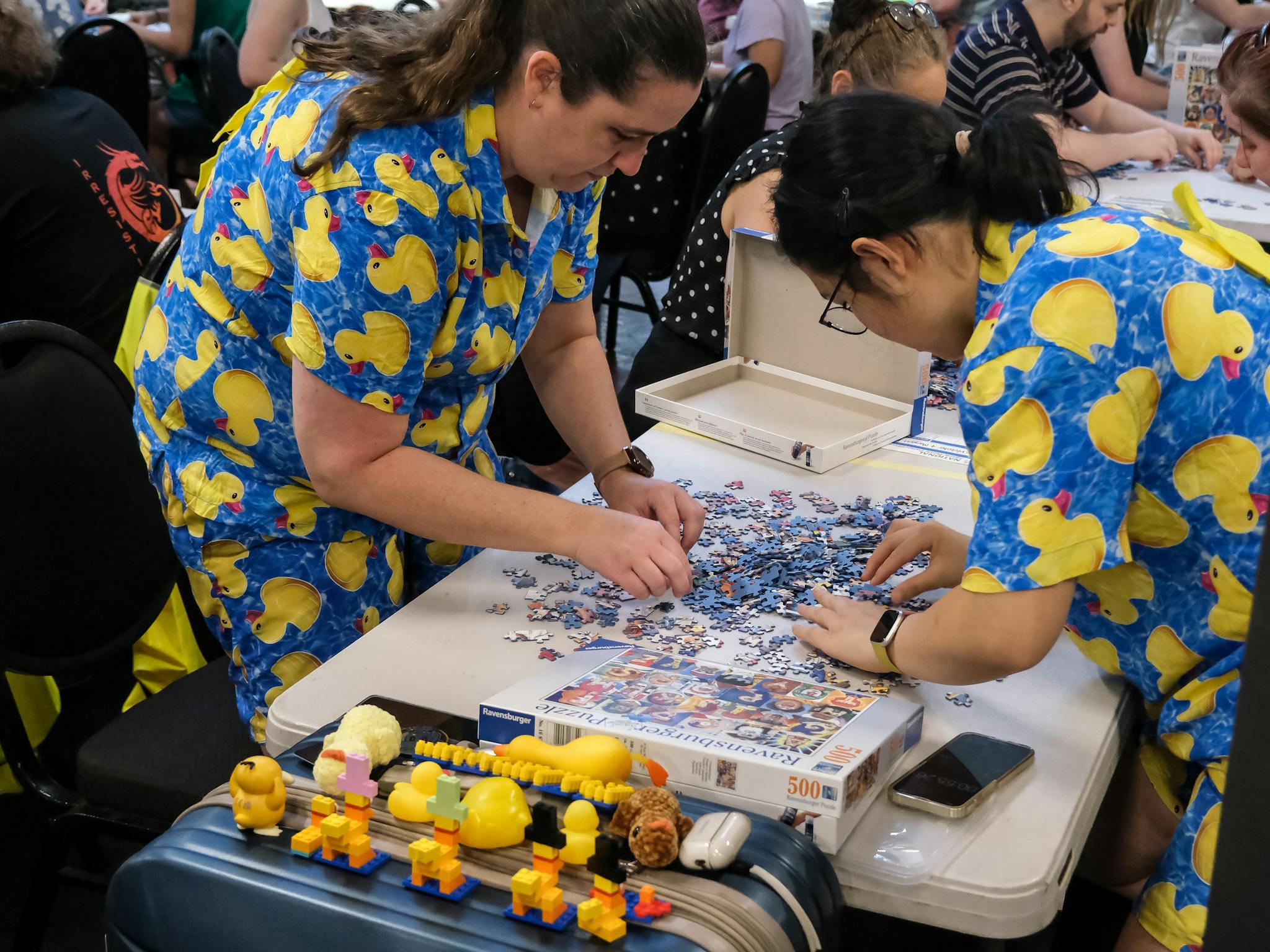 Two women in duck outfits complete a puzzle