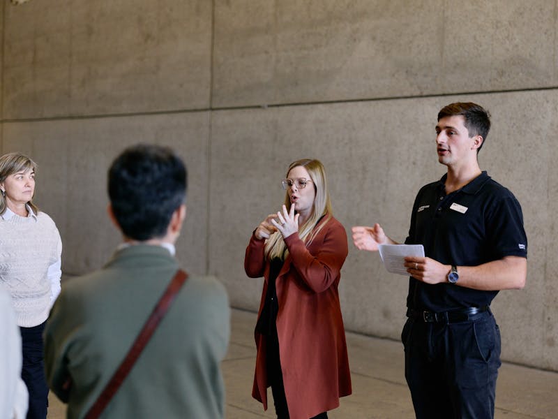 An Auslan interpreter and museum guide lead a tour group