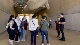 Visitors join a tour in the Whale Mall outside Queensland Museum Kurilpa