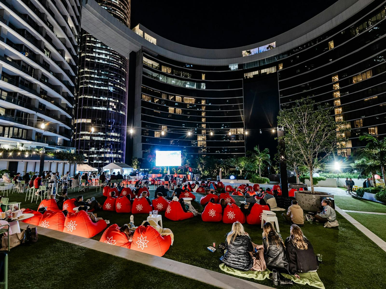 People at an outdoor cinema behind Queen's Wharf