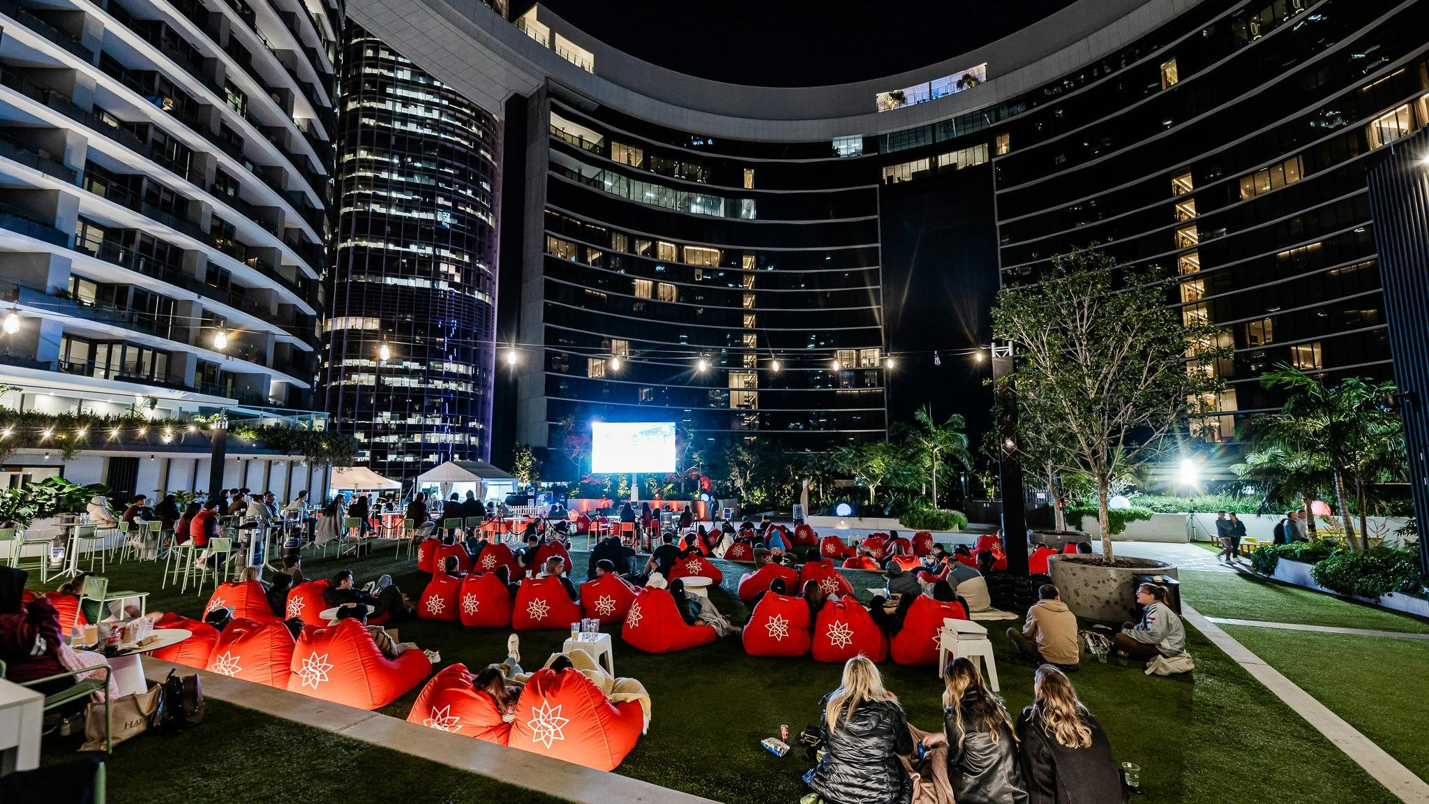 People at an outdoor cinema behind Queen's Wharf