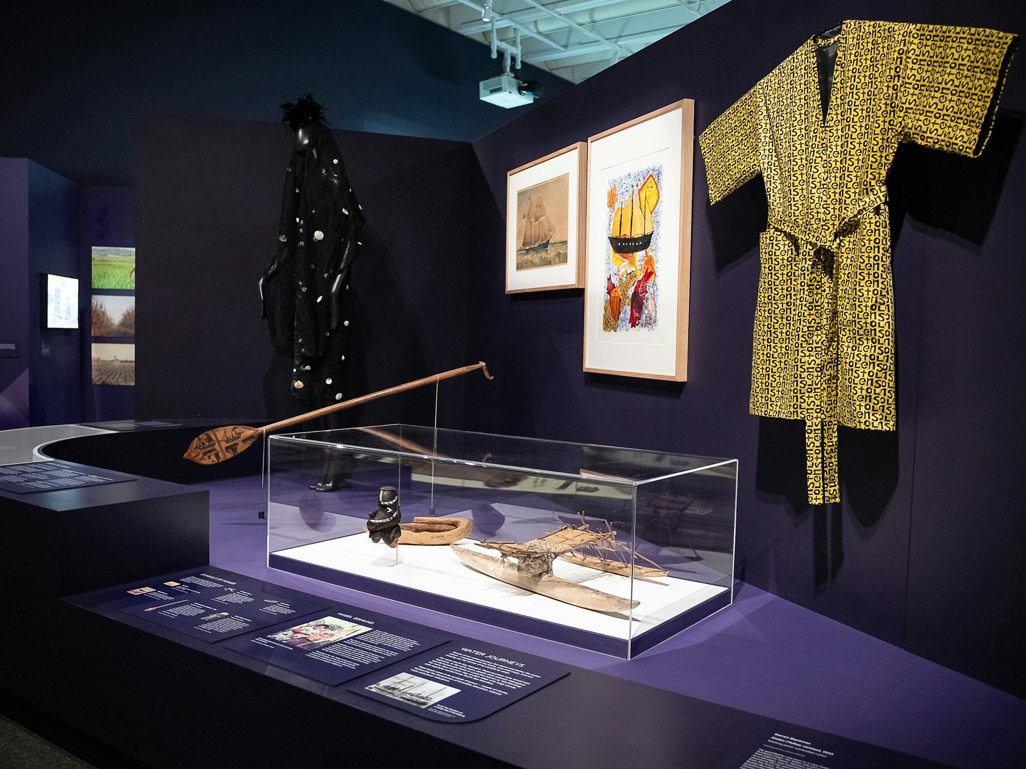 An exhibition space with objects on display including a yellow smoking jacket