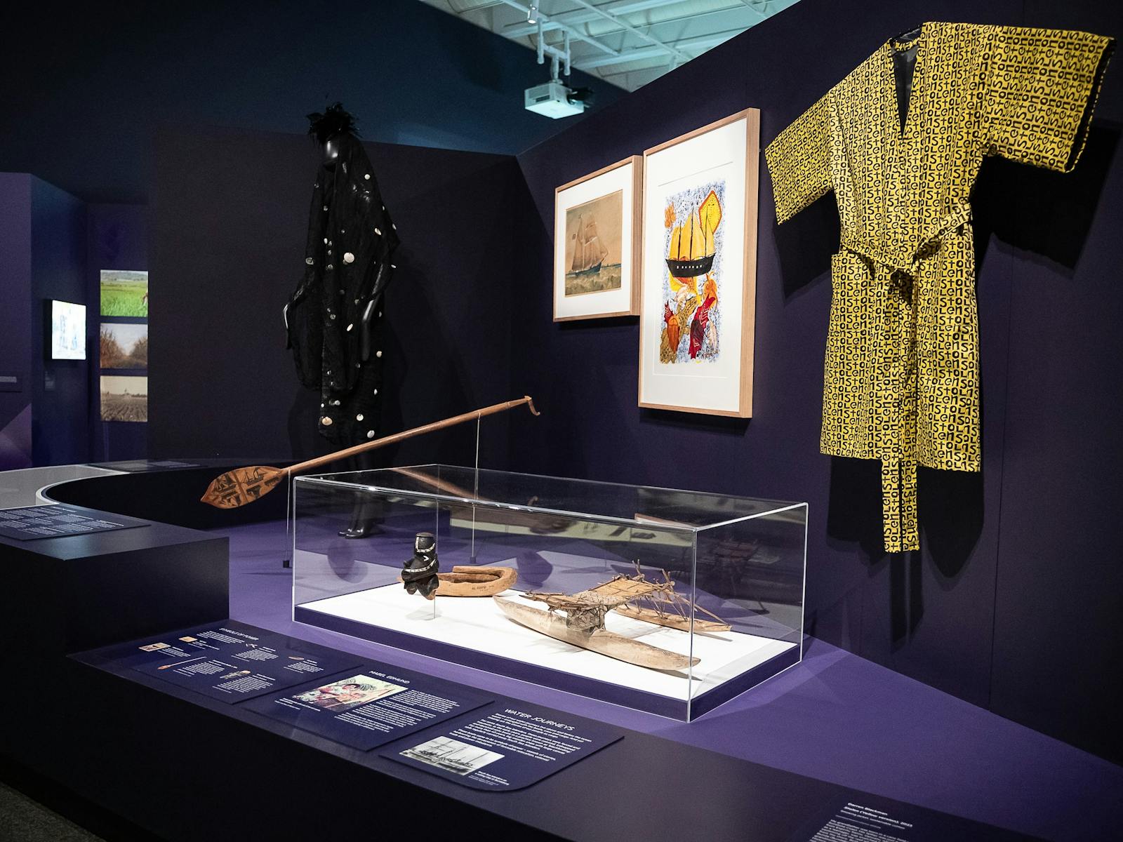 An exhibition space with objects on display including a yellow smoking jacket