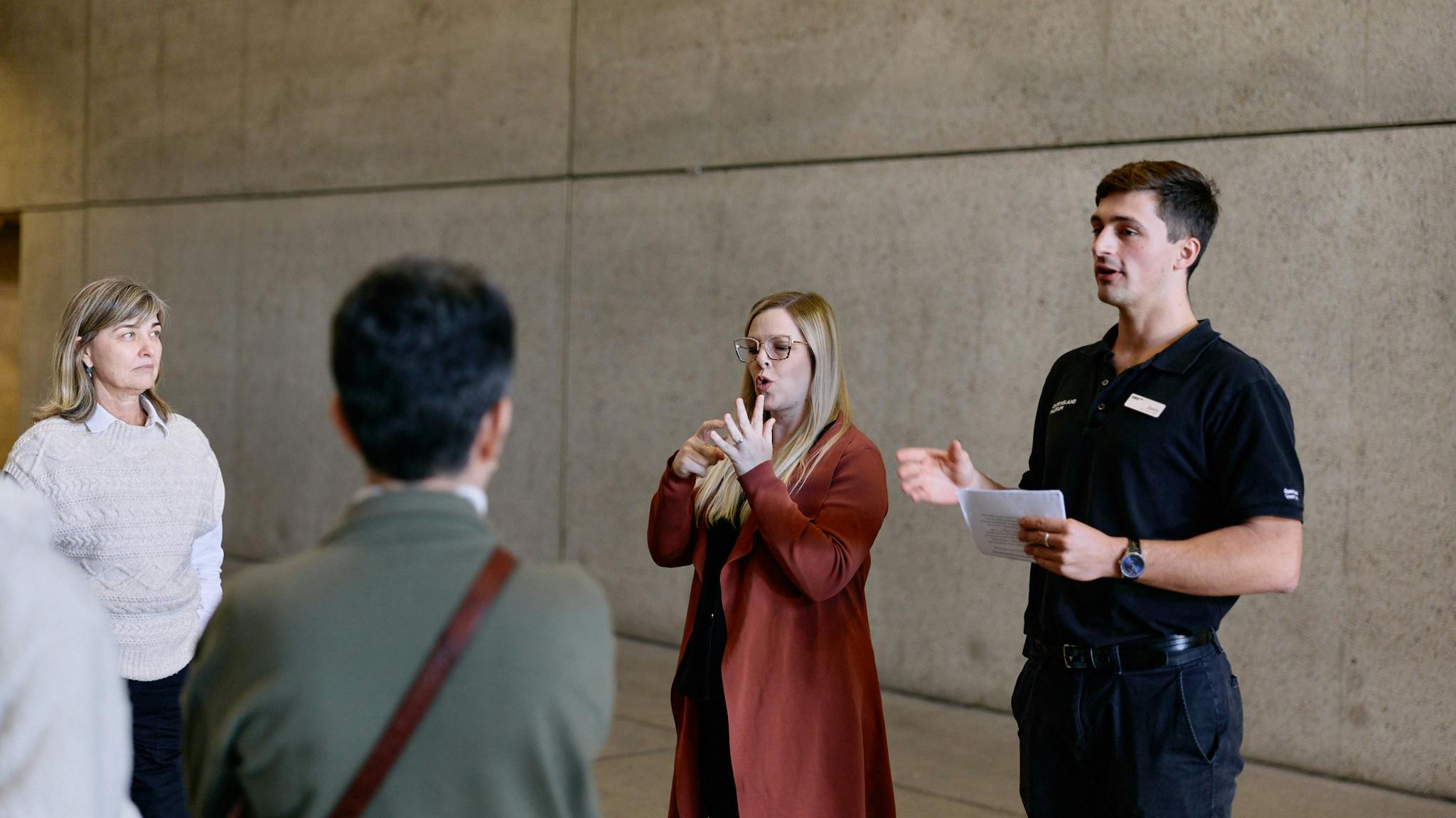 An Auslan interpreter and museum guide lead a tour group