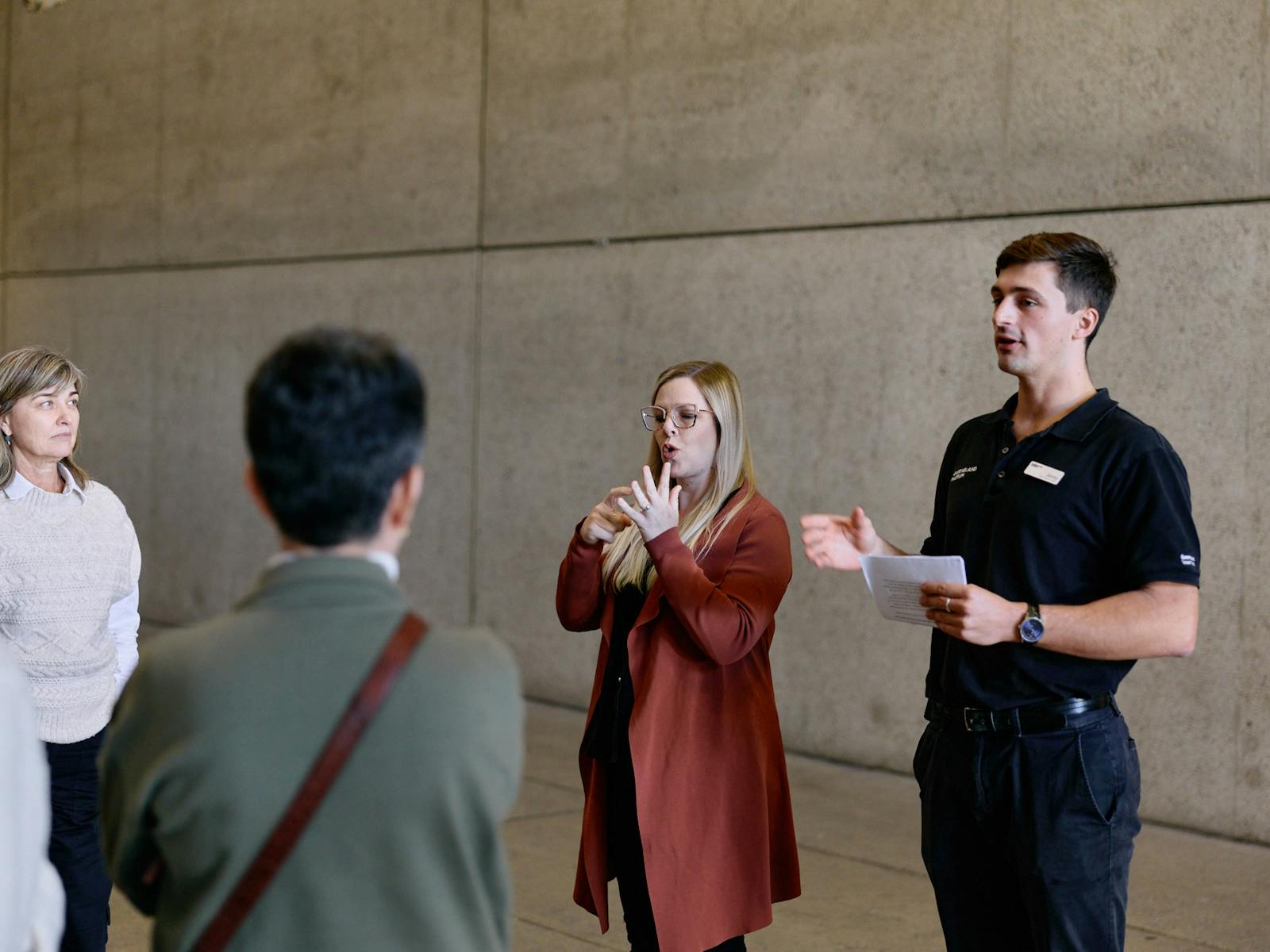 An Auslan interpreter and museum guide lead a tour group
