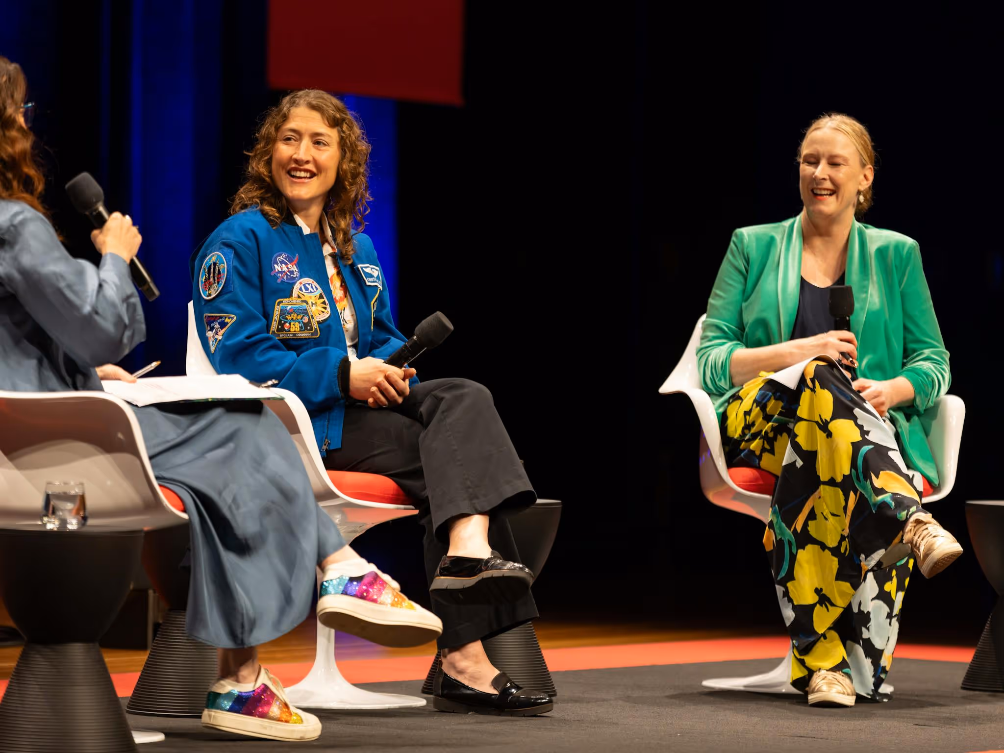 Three woman talking on stage