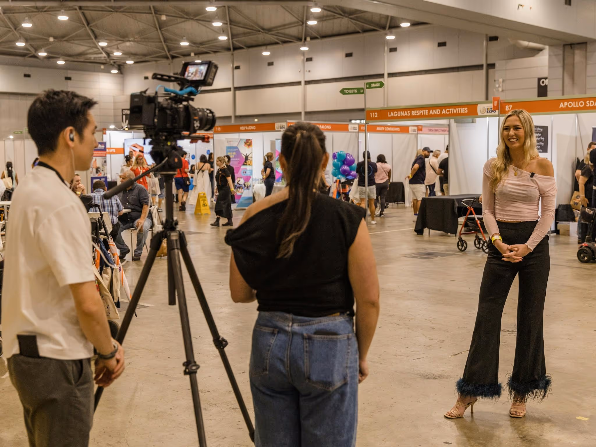 Two staff members interviewing Ambassador Anja Christoffersen at Brisbane 2024
