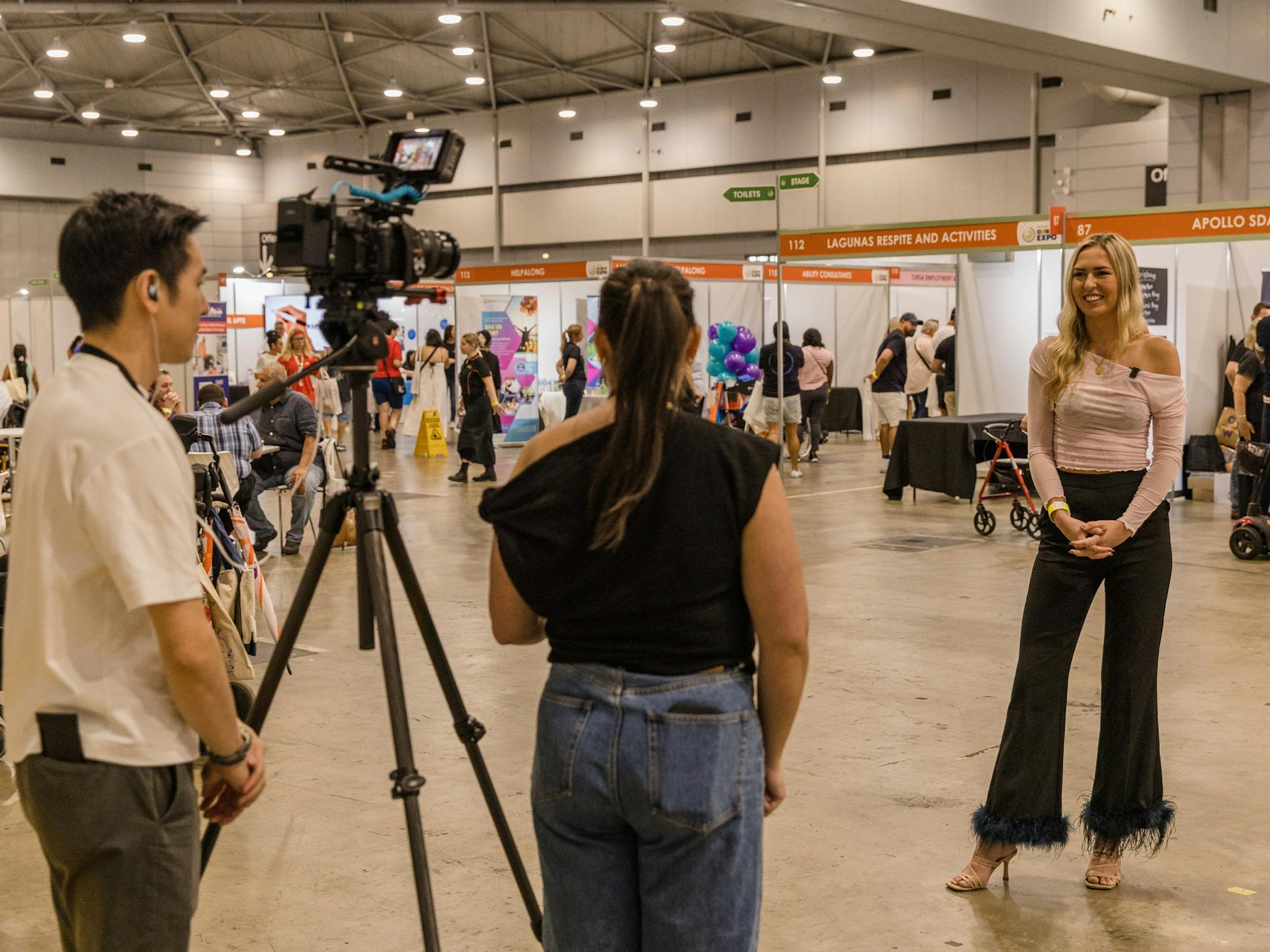 Two staff members interviewing Ambassador Anja Christoffersen at Brisbane 2024