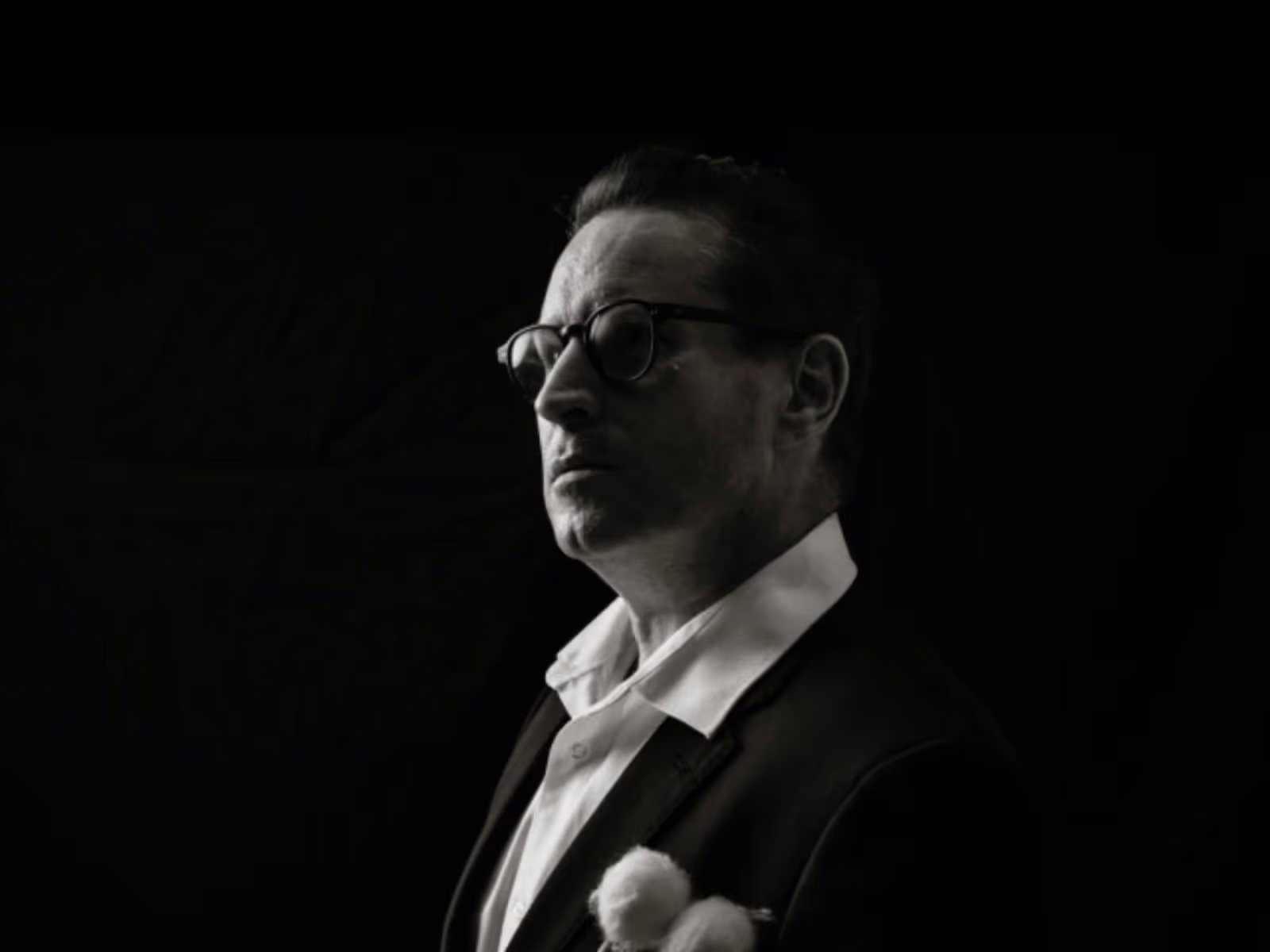 Black-and-white portrait of a timpanist in profile, looking toward the light