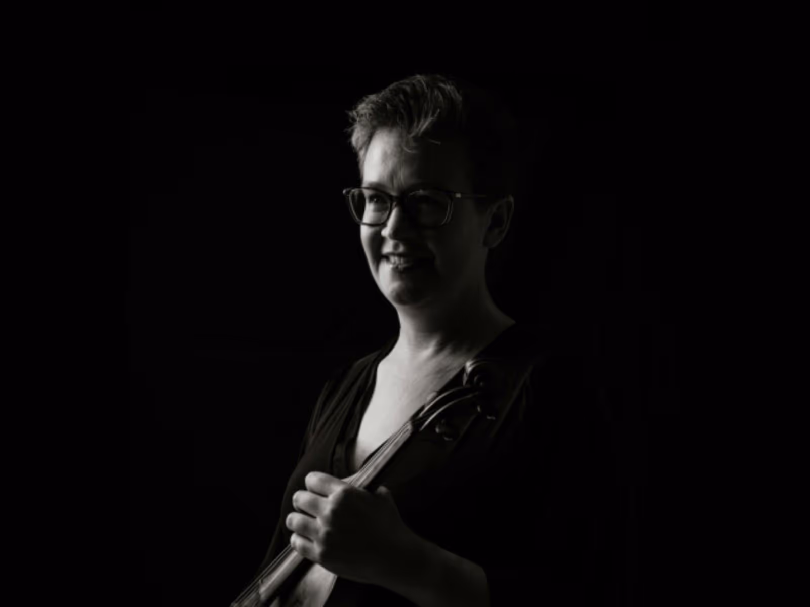 Black-and-white portrait of a violinist in profile, looking toward the light