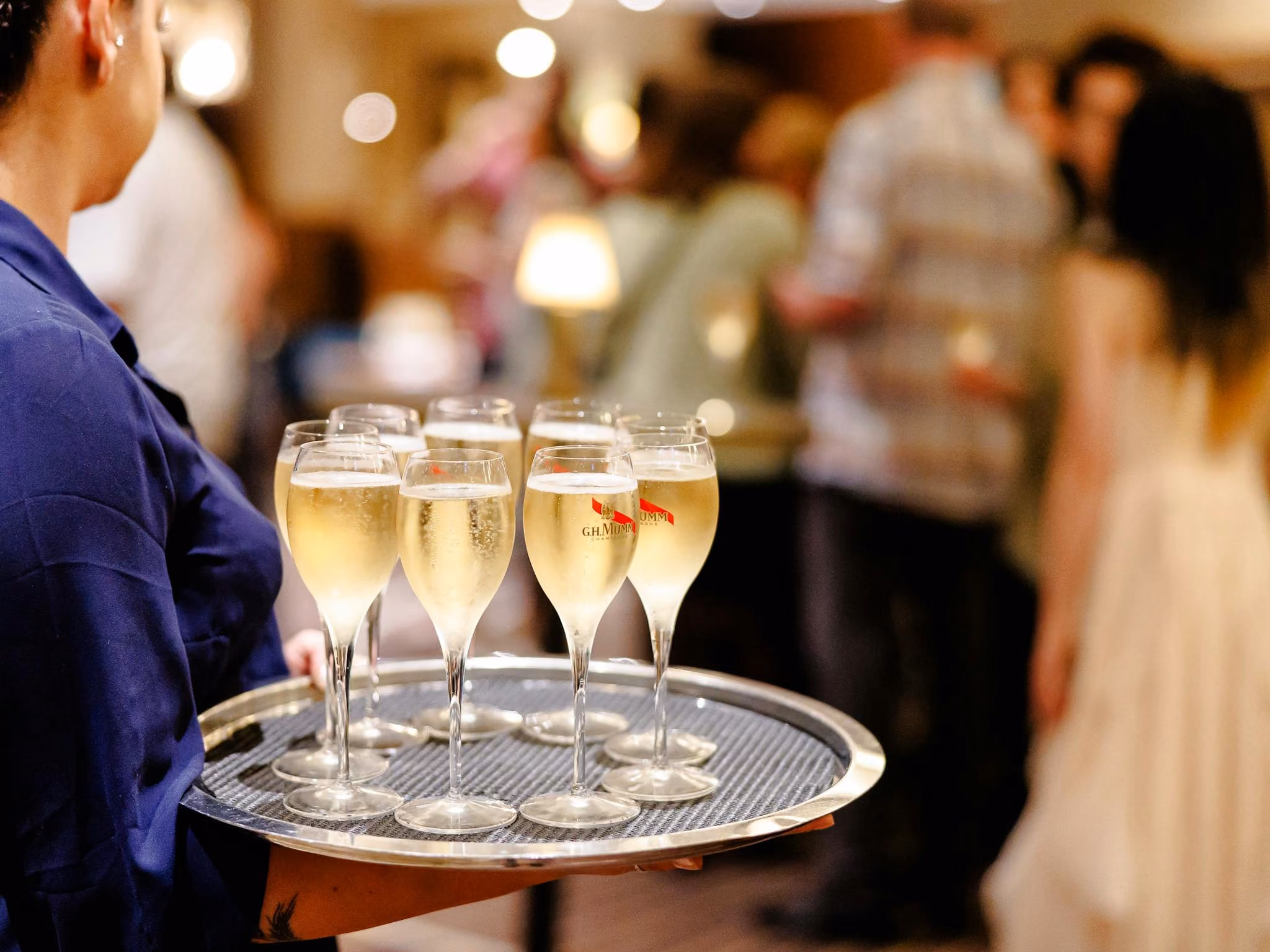 Staff member serving glasses of sparkling wine to guests at Rydges South Bank Brisbane