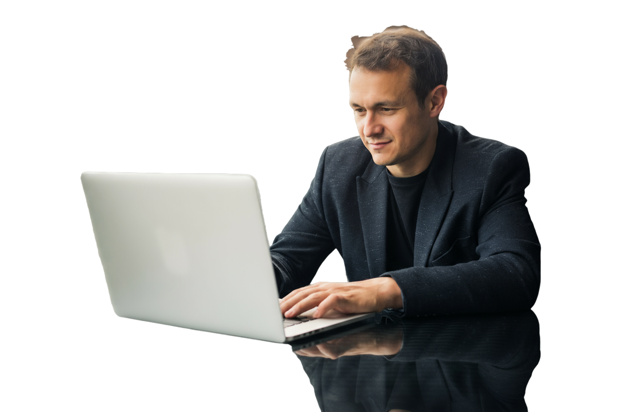 A smiling man working on a laptop