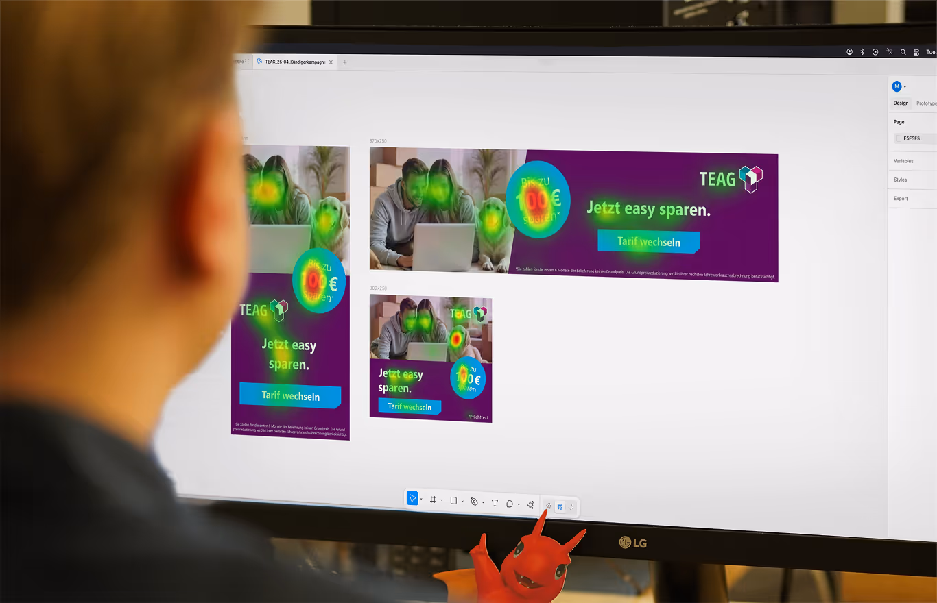 A person looks at a computer monitor displaying heatmaps over TEAG digital advertisements to analyze eye-tracking data and visual attention.