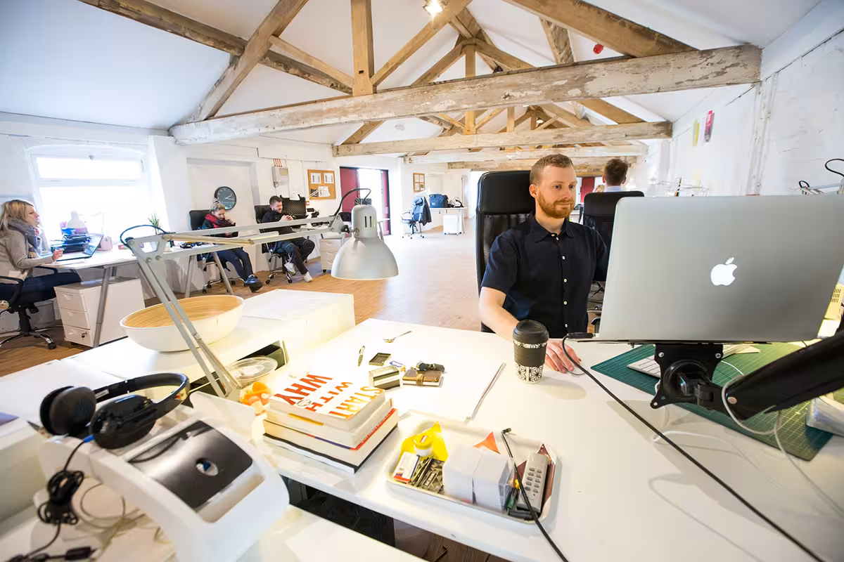 An image depicting several people working at desks