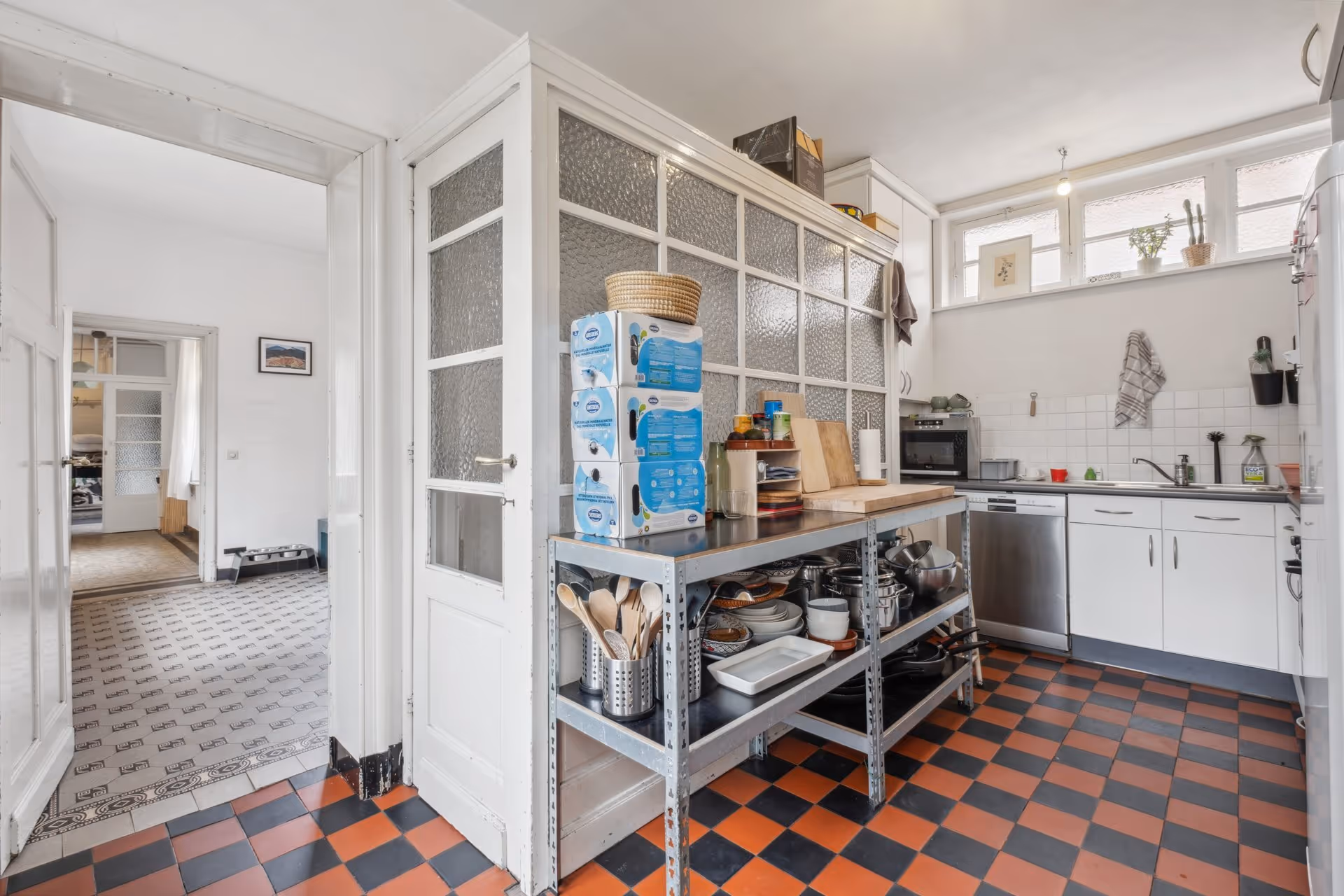 A kitchen with a checkered floor and white cabinets.