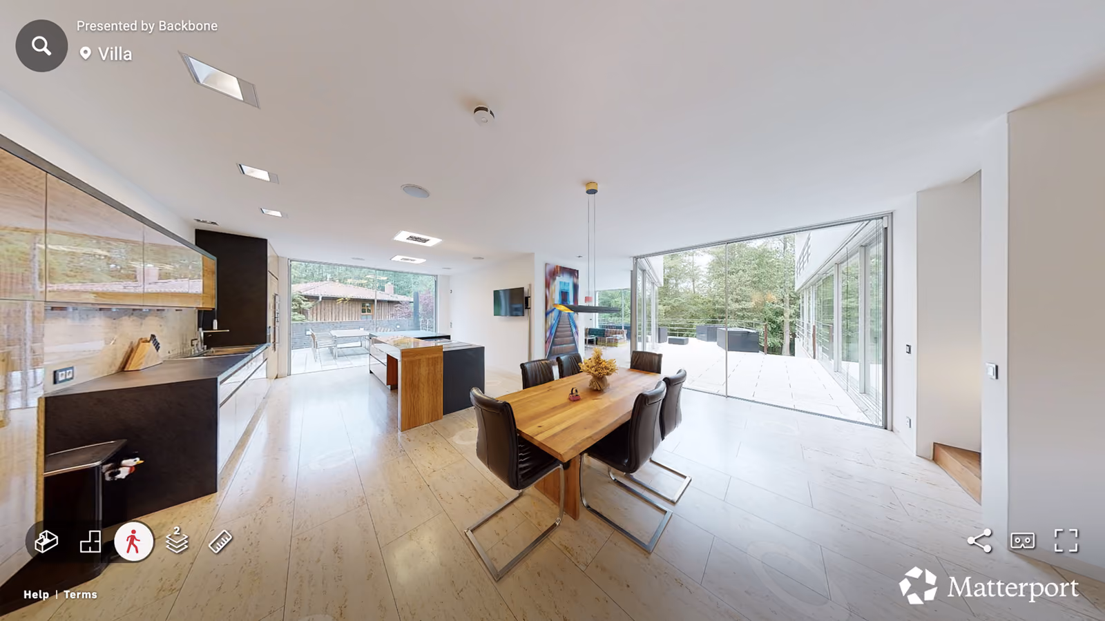 Modern open kitchen and dining area with wood table, black chairs, large windows, and outdoor patio view.