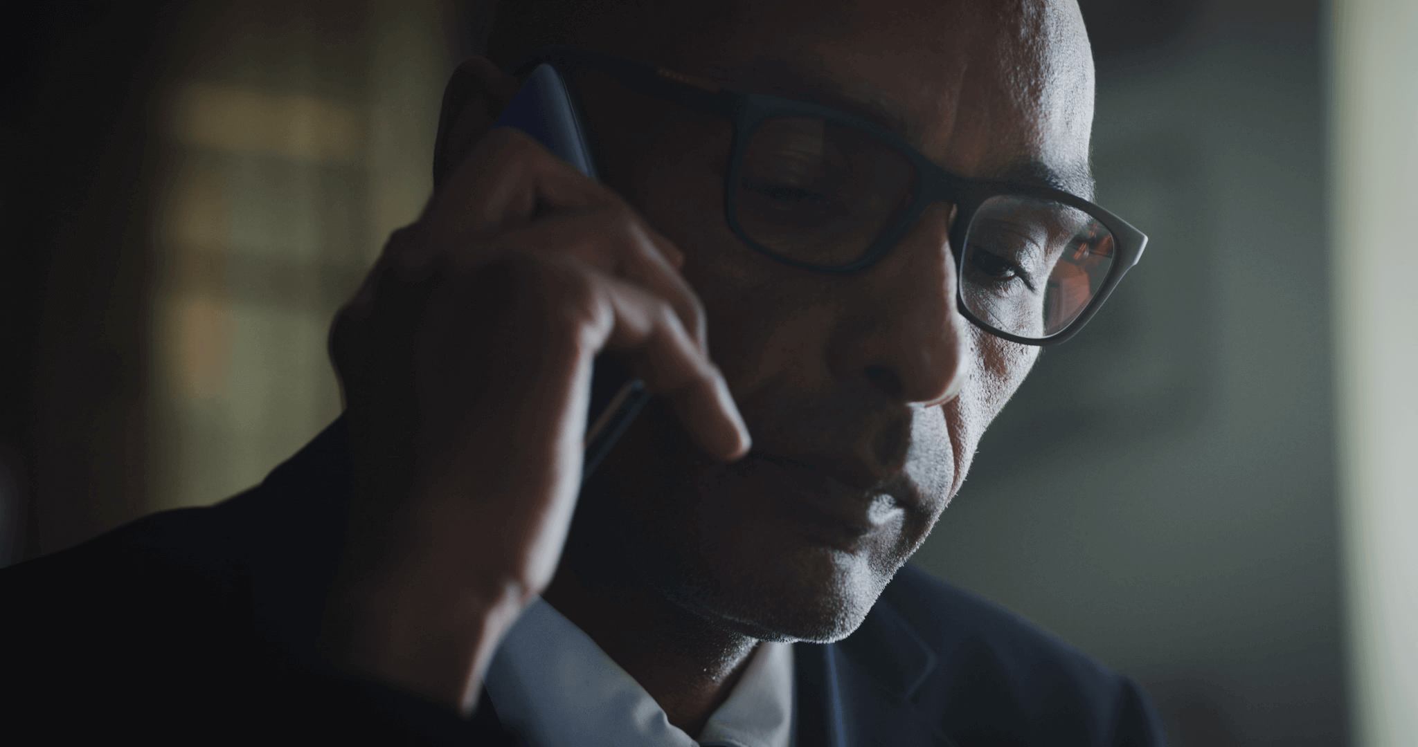 Close-up of man on phone during a serious conversation representing how attackers use voice-based deception to exploit urgency and trust during vishing attacks.
