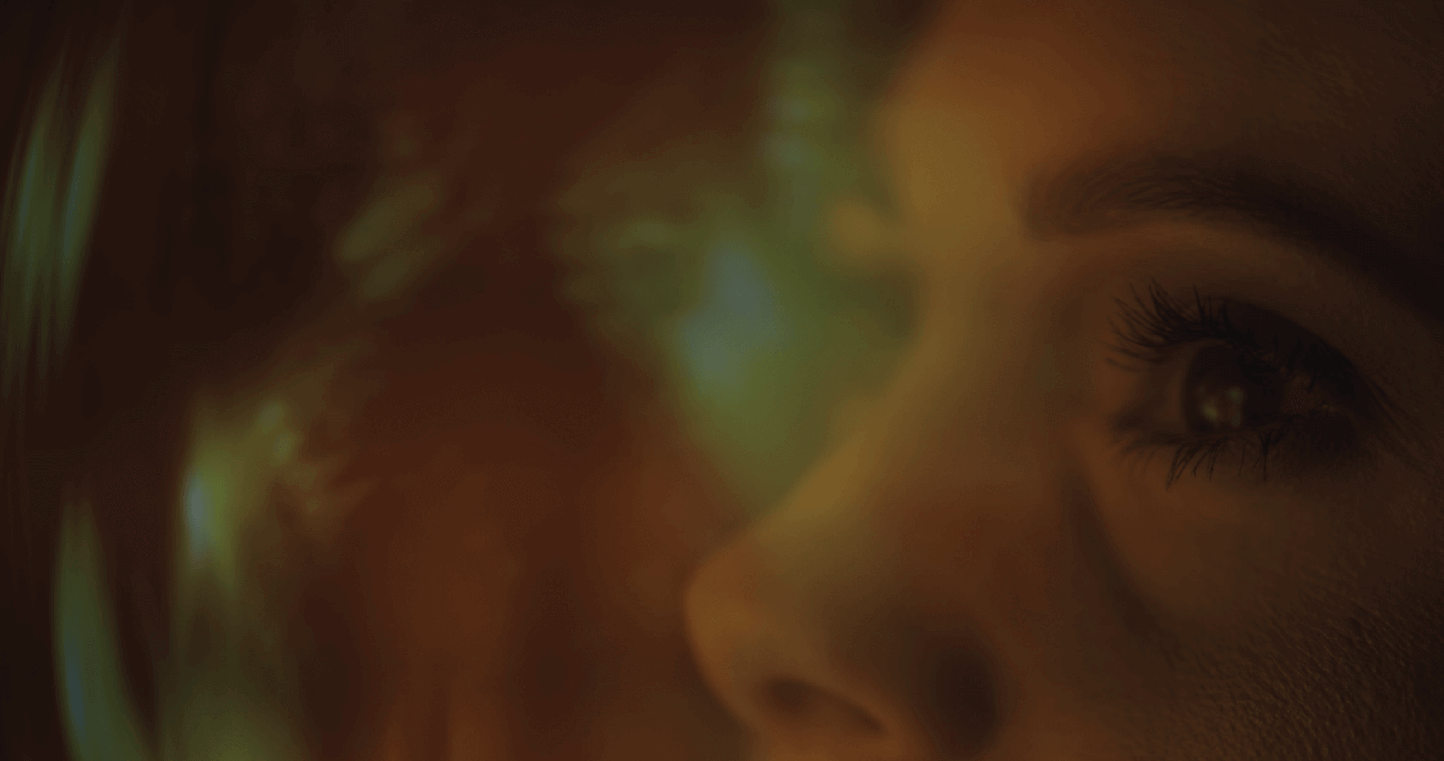 Stylized close-up of a woman’s face illuminated by soft digital light, representing how vishing attacks target individual users through voice-based manipulation, emotion, and trust.