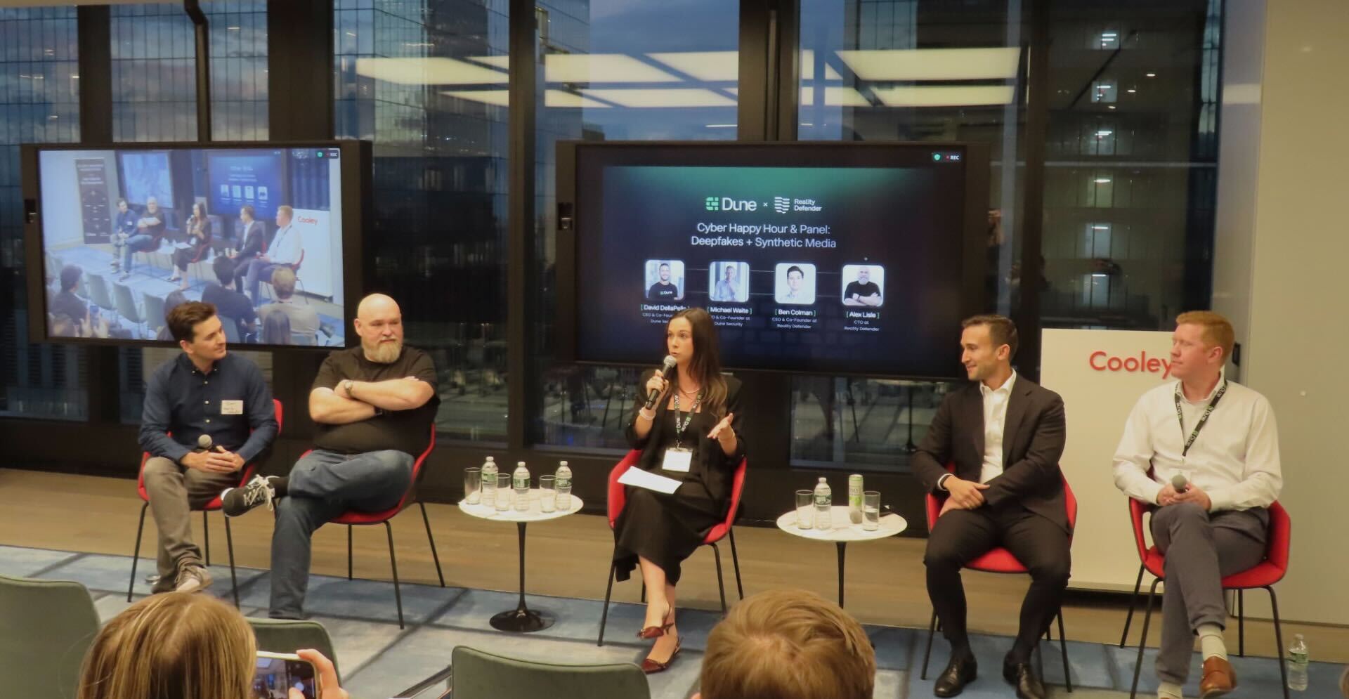 Photo of the Deepfakes & Synthetic Media: Cyber Happy Hour & Panel hosted by Dune Security and Reality Defender at Cooley LLP in New York City. The image shows moderator Kaila Mathis leading a discussion with panelists Ben Colman, Alex Lisle, David DellaPelle, and Michael Waite on how enterprises can defend against deepfake and synthetic media threats.  