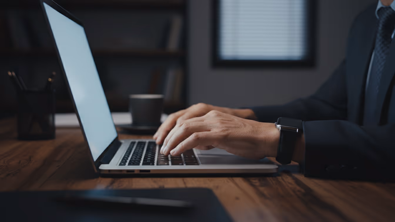 Close-up of a Business Process Outsourcing support agent typing at a workstation, representing social engineering risk in BPO workflows.